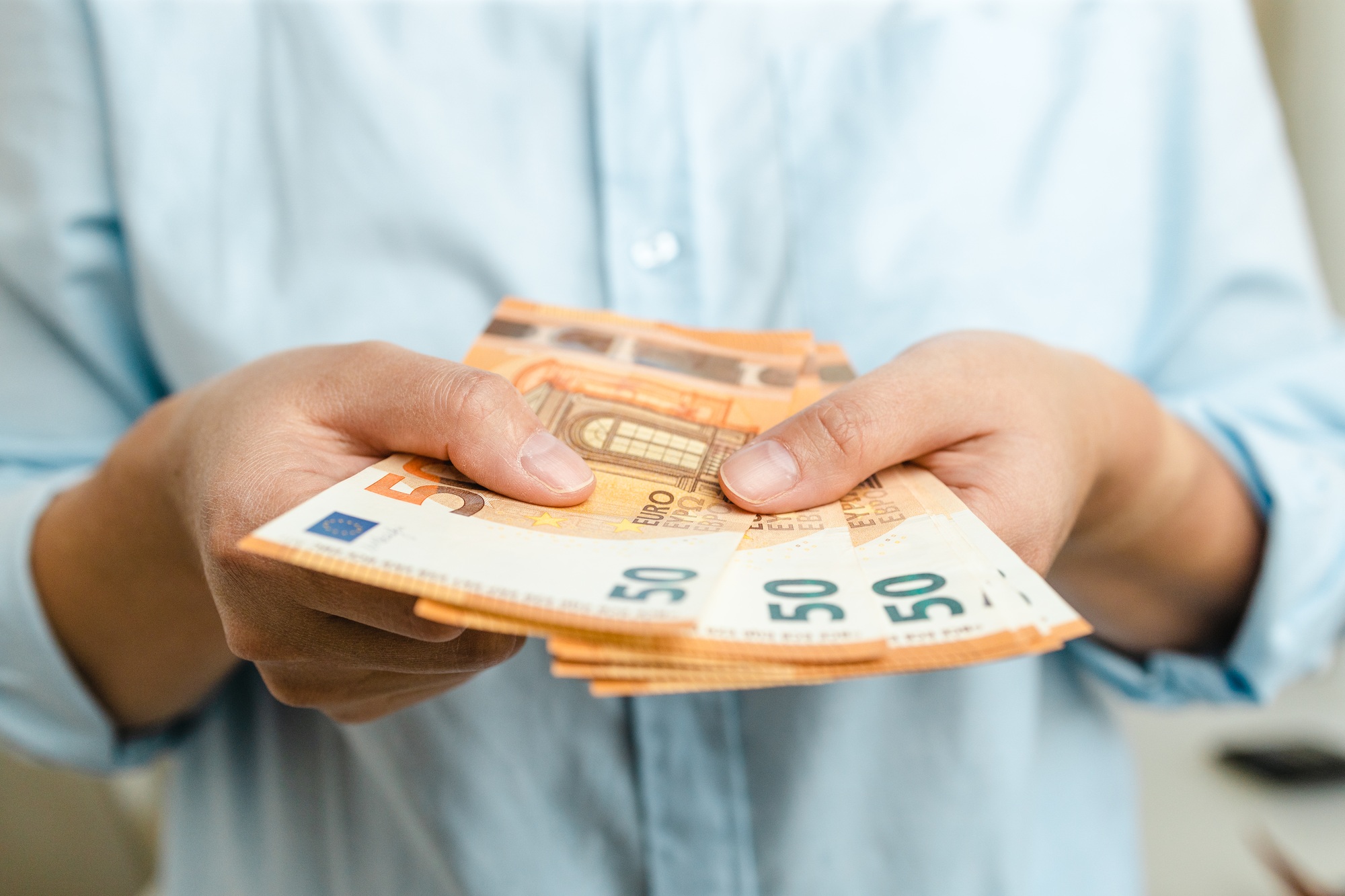 Woman hands with euro money on grey background