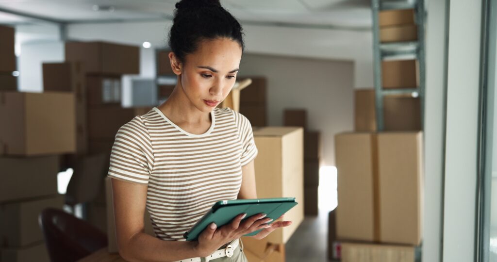 Woman, tablet and typing in business for logistics, order process and package checklist in office.